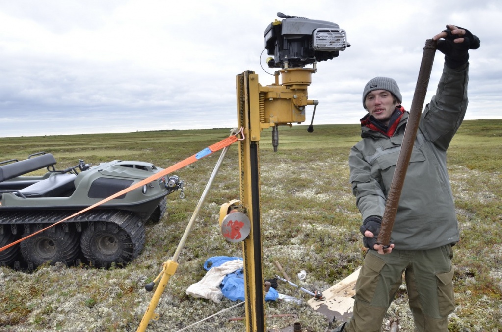 Аспирант ТГУ Егор Истигечев демонстрирует керн мерзлого торфа. Фото Сергея Лойко